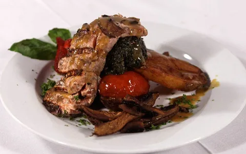 A plated entrée with vegetables.